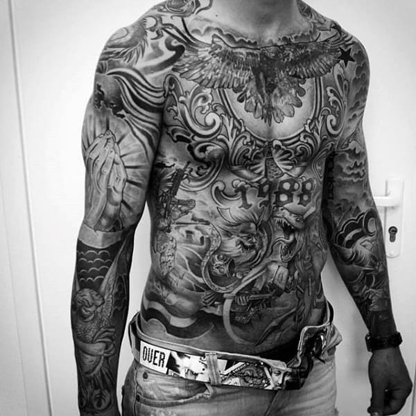 Tattoo-covered man displaying intricate designs on his torso and arms