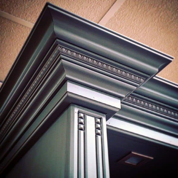Close-up of detailed, ornate crown molding with intricate designs and a glossy finish, adding sophistication to the room