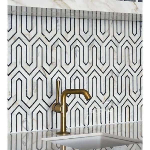 Intricate geometric backsplash pairs with marble and a brushed gold faucet for a bold statement.