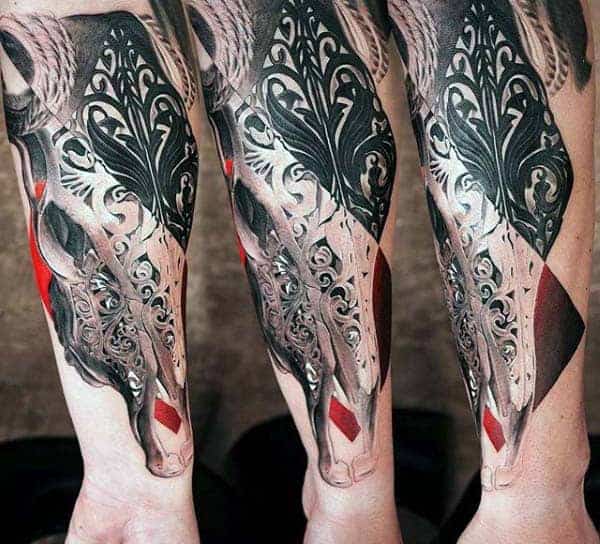 Intricate black and red deer tattoo on a person's forearm