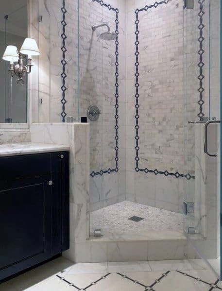 Elegant corner bathroom with glass shower, white and gray tiles, black accents, and a dark vanity with a wall-mounted light