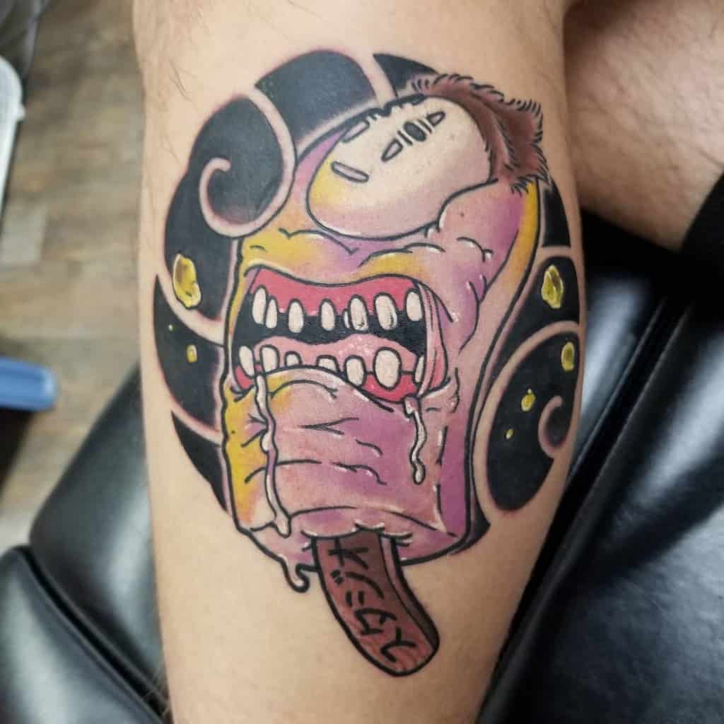 Bold tattoo of No-Face in monstrous form from Spirited Away, with exaggerated features, sharp teeth, and a distorted expression in vibrant colors