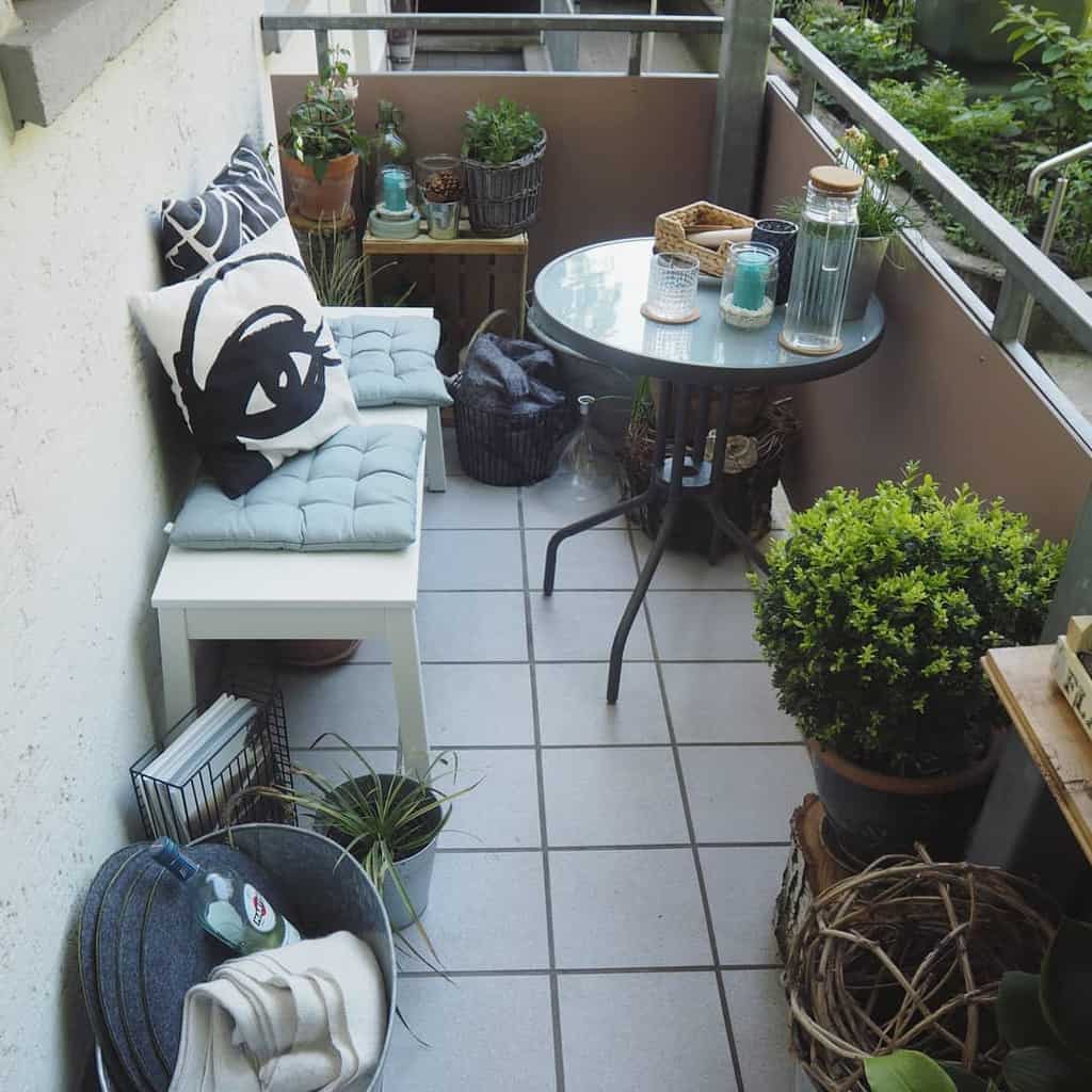 Small balcony with cozy seating, round table, and decorative plants in a compact space.
