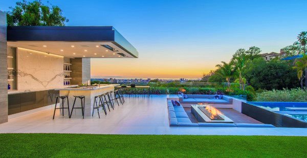 Sleek outdoor bistro bar with island seating, fire pit lounge, and pool overlooking scenic views.