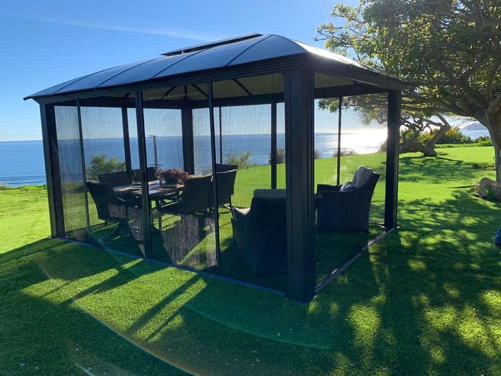 outdoor enclosed gazebo wicker furniture large grass area 