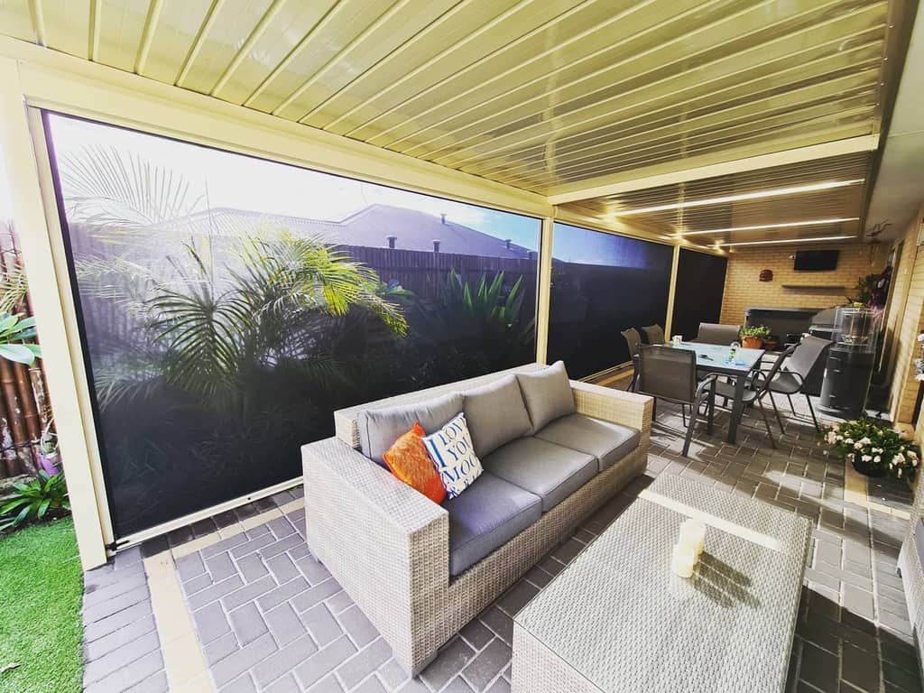 outdoor enclosed patio paver floor wicker couch and glass top table desk and chairs 