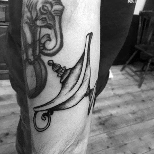 A tattoo of an ornate genie lamp on a person's arm