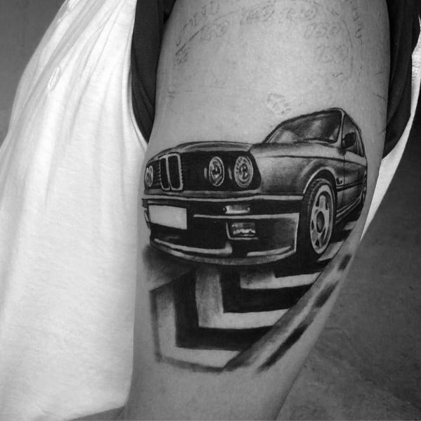Realistic BMW E30 tattoo on upper arm, featuring bold shading and a geometric background for a striking and dynamic automotive design.
