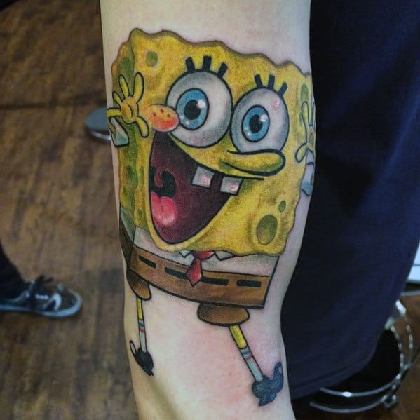 Vibrant SpongeBob tattoo with wide eyes and open mouth, mid-jump with arms up, radiating excitement and joy.