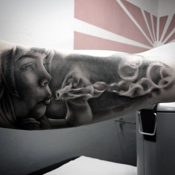 Black and grey tattoo of a person blowing bubbles, with a seahorse emerging from one bubble, surrounded by soft, ethereal shading for a dreamy effect.