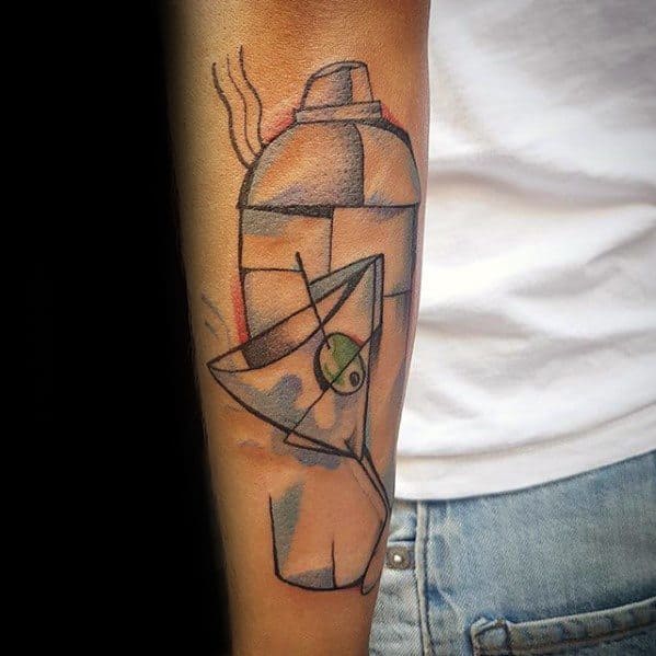 Cubist tattoo on the forearm featuring an abstract martini glass with an olive and a cocktail shaker, accented with soft pastel colors.