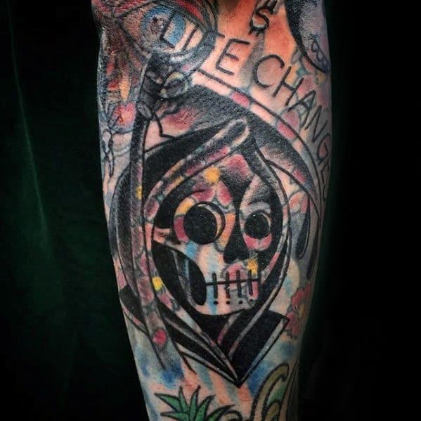 Blast over tattoo of a colorful hooded skull with abstract designs and text on an arm