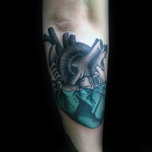 Creative tattoo of an anatomical heart sinking into the ocean, with a shipwreck inside the water, blending emotion and nautical symbolism.