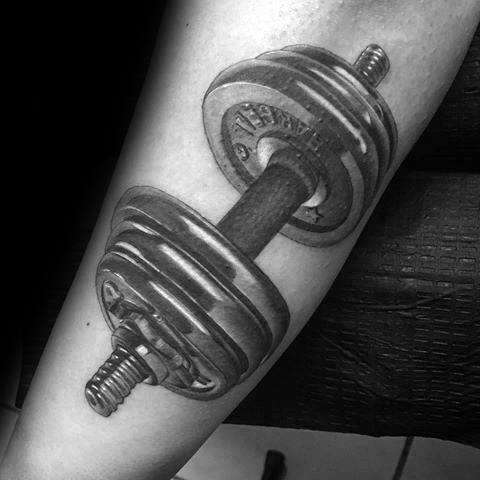 Realistic black and gray dumbbell tattoo on the forearm, showcasing intricate shading and depth for a bold fitness-inspired design.