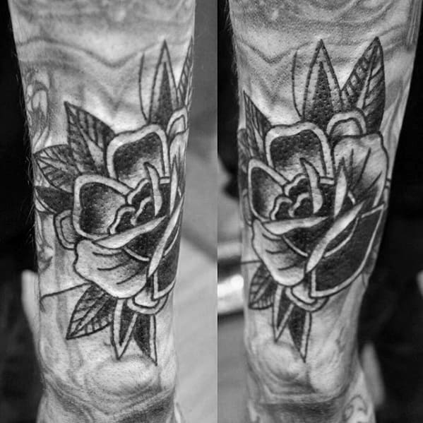 Blast over tattoo of a black and white rose with leaves on a person's arm