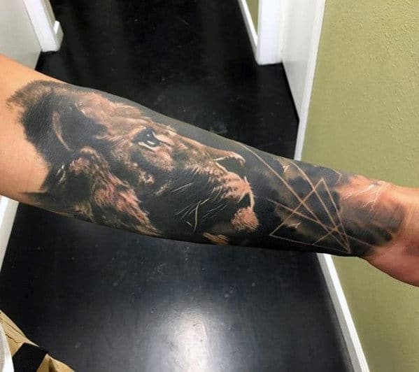 Forearm tattoo of a realistic lion's face with geometric shapes