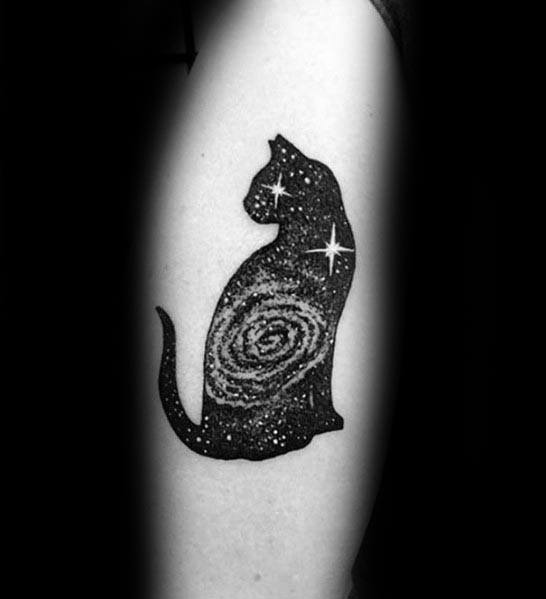 Cosmic blackwork cat tattoo featuring a galaxy and starry details within its silhouette, creating a mystical and celestial design.