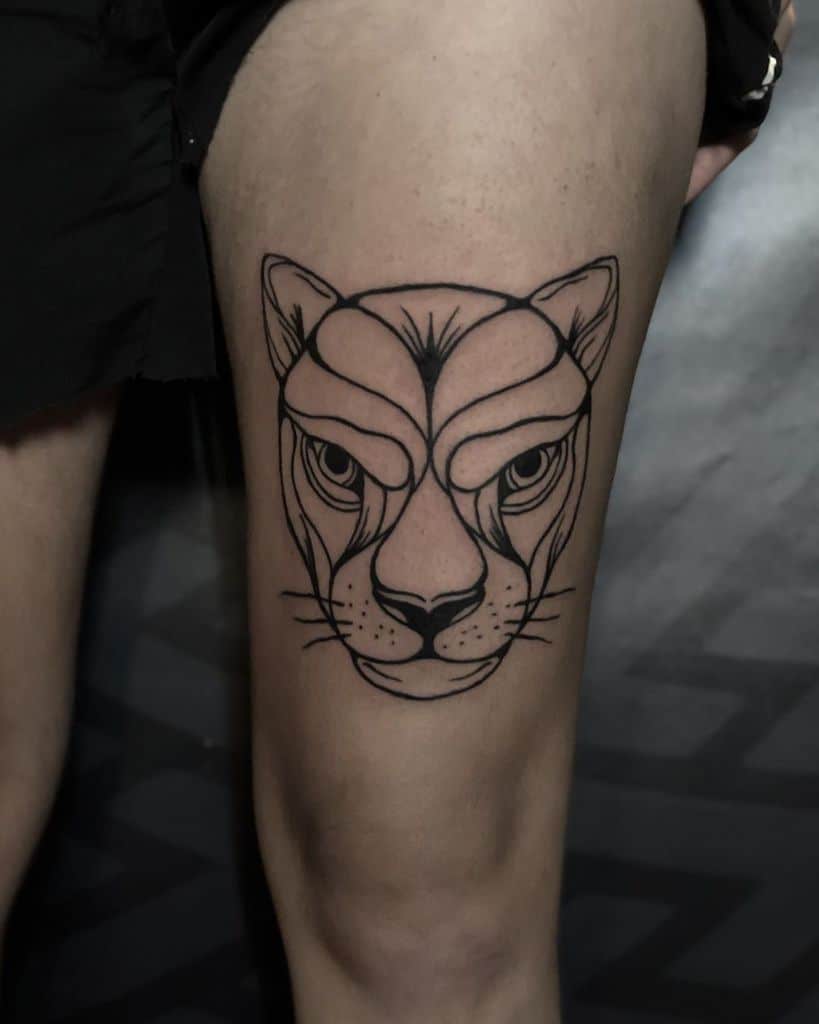 Bold geometric lioness tattoo on the thigh, featuring thick black lines and sharp details for a modern and fierce look.