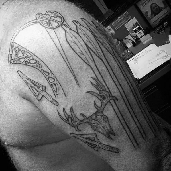 Linework tattoo on the upper arm featuring bow components, arrows, broadheads, and a deer skull with antlers in a clean, minimal style.