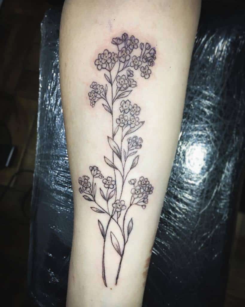 Forget-me-not flowers delicately outlined in black ink, showcasing a minimalistic and meaningful design on the forearm