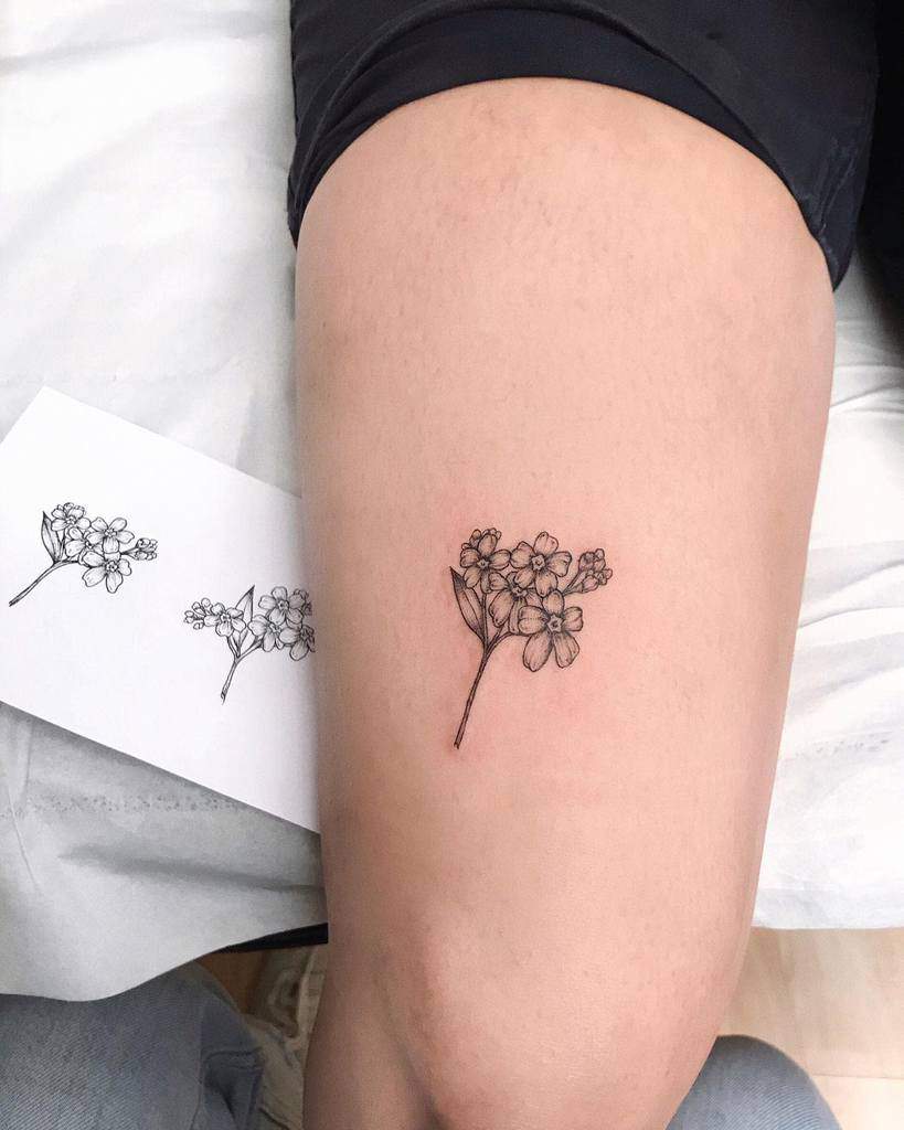 A simple and elegant black outline tattoo of forget-me-not flowers, designed for the thigh, with fine details capturing their beauty