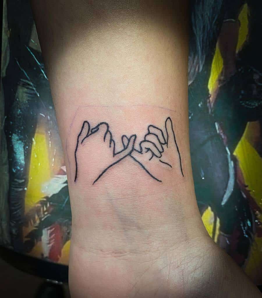 Line art tattoo of two hands linking pinky fingers on a wrist