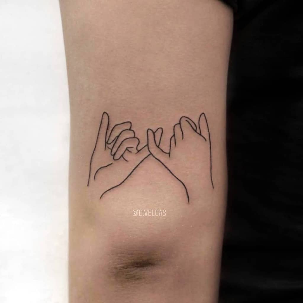 Line art tattoo of two hands making a pinky promise, located on an inner arm