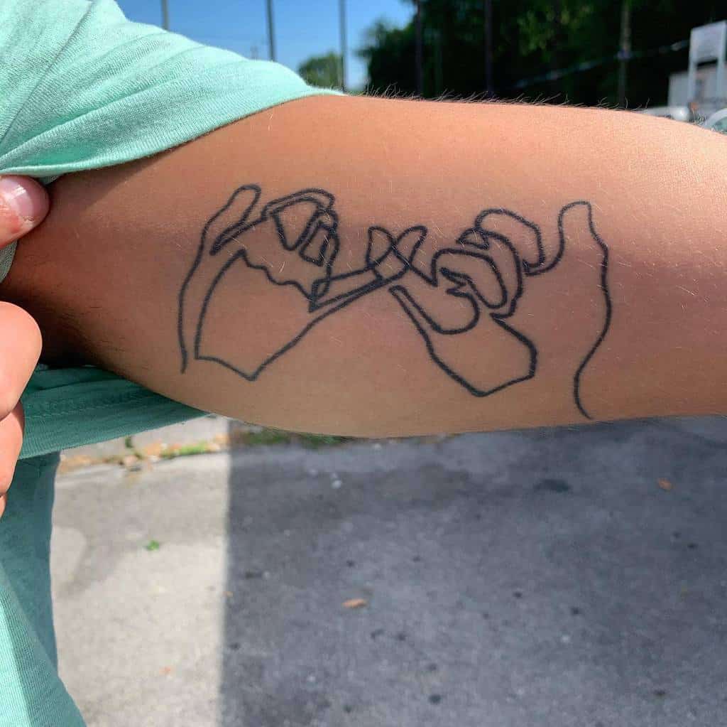 Line art tattoo of two hands making a pinky promise on a bicep