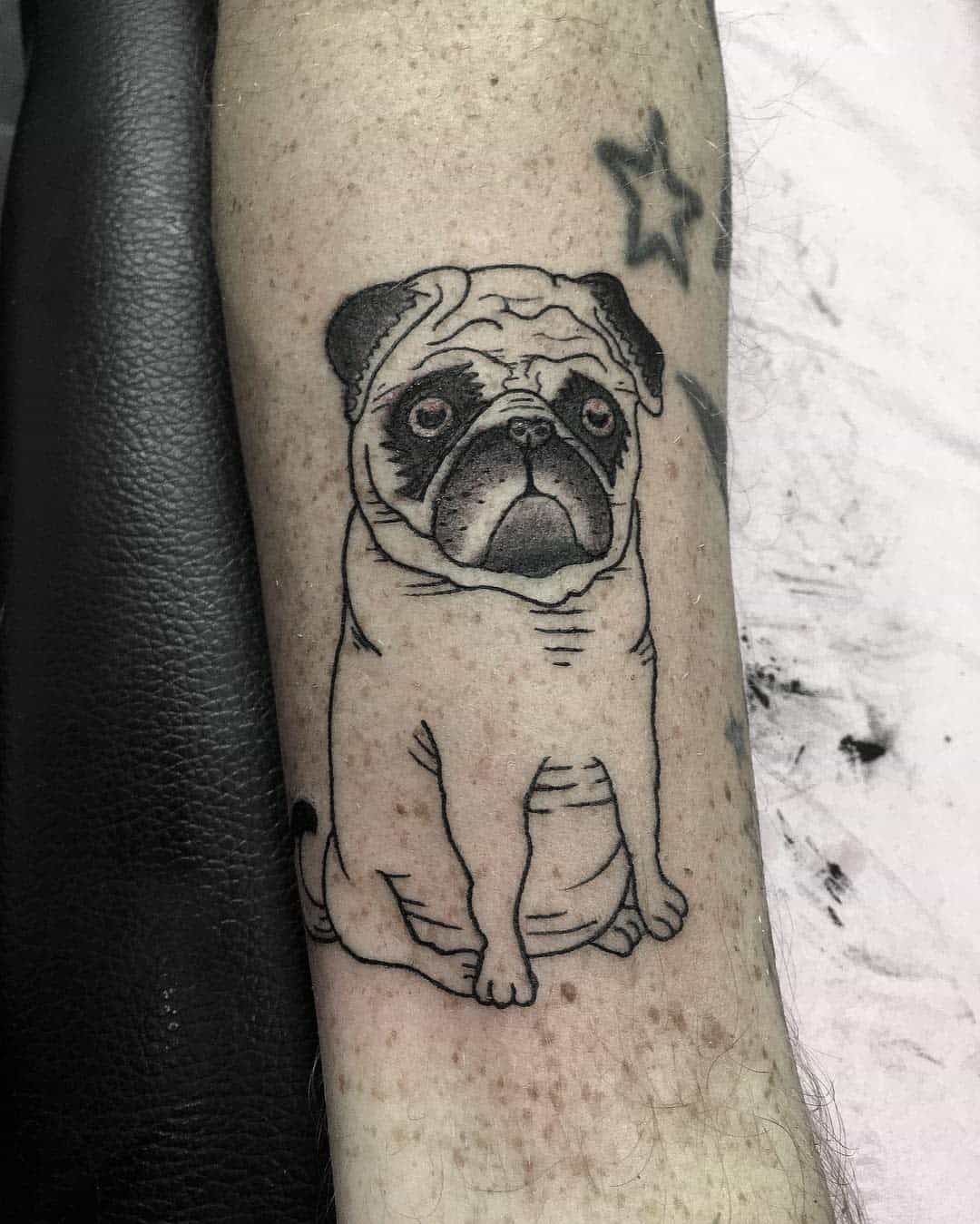 A black-and-white line tattoo of a sitting pug with a slightly grumpy expression