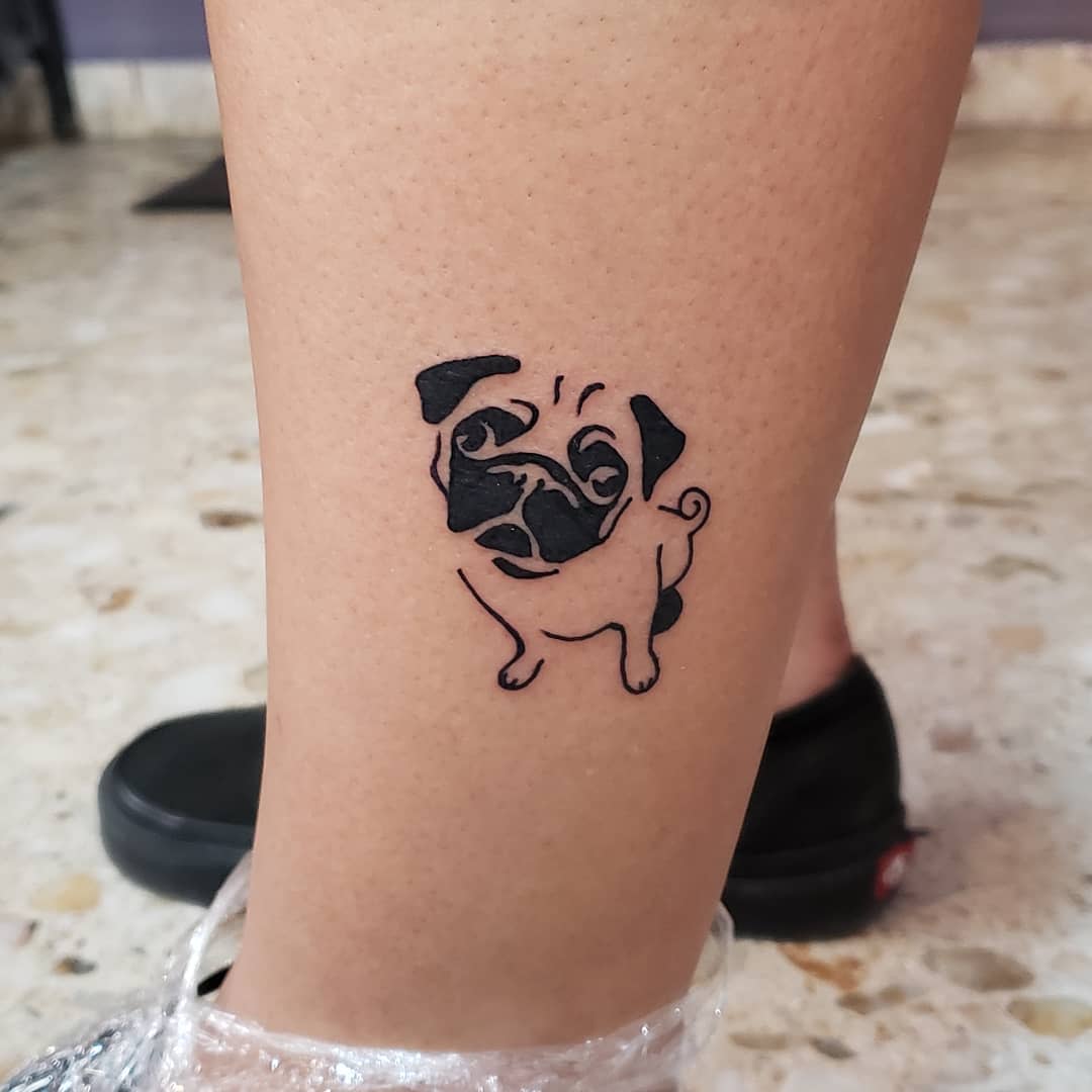 A simple black-line tattoo of a cute pug standing, with exaggerated facial features and a curly tail