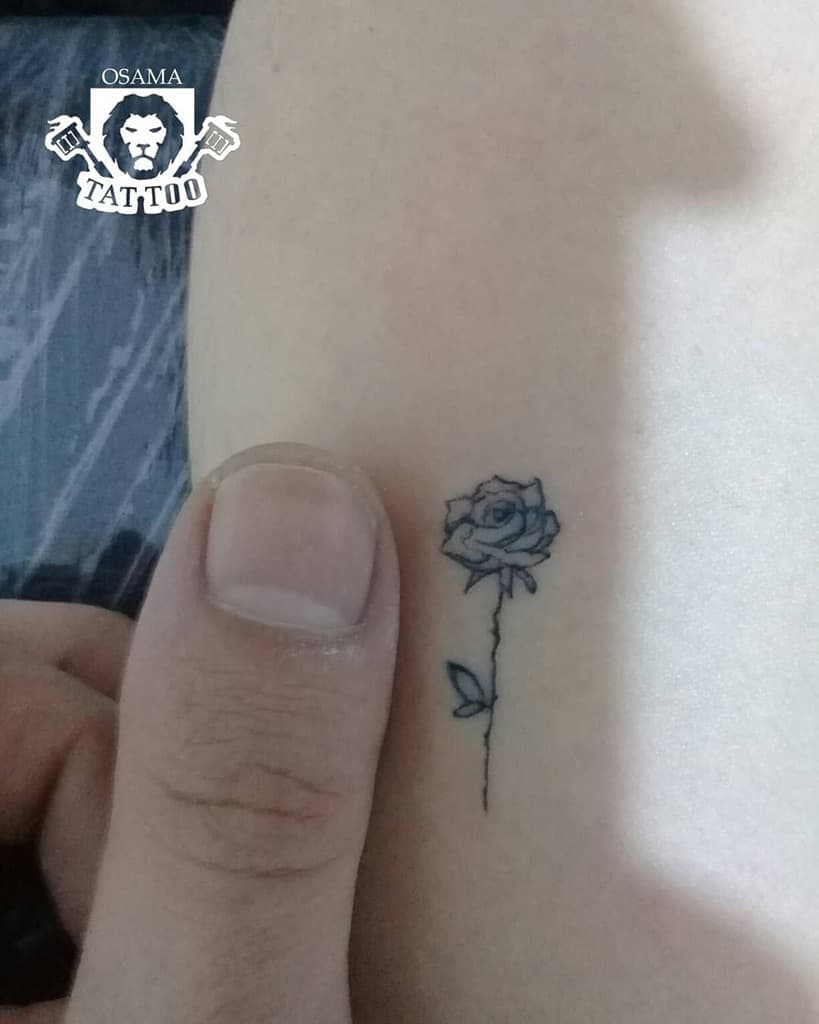A small outline rose tattoo on skin