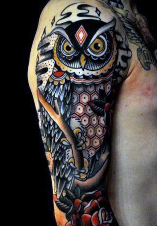 Tattoo of an intricate owl design covering a person's upper arm and shoulder