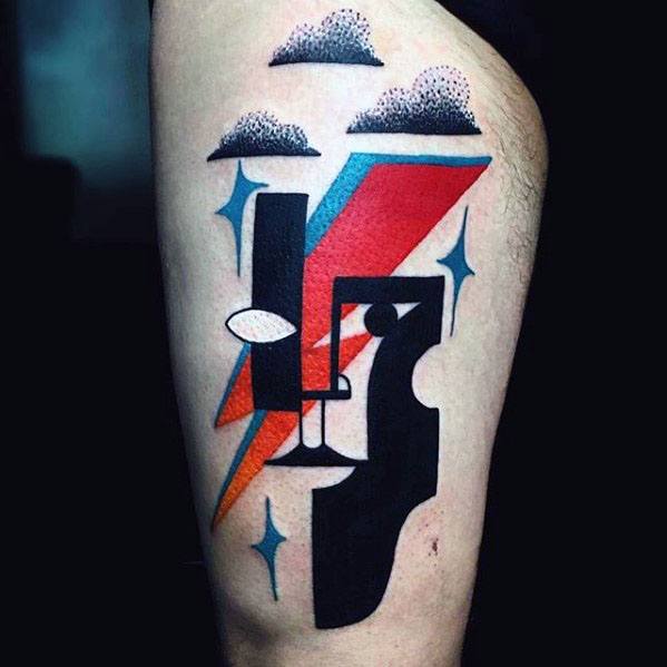 Colorful Picasso-inspired tattoo featuring an abstract face with a bold red and blue lightning bolt, stylized clouds, and spark elements.