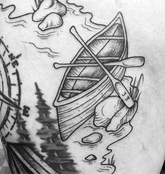Black and grey tattoo of a wooden rowboat with crossed paddles on a calm shoreline, symbolizing adventure, solitude, and a love for nature.