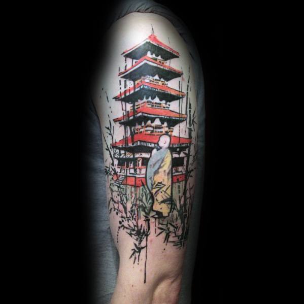 Colorful upper arm tattoo of a red Japanese pagoda with a monk in yellow robes and bamboo accents in a painterly, watercolor style.