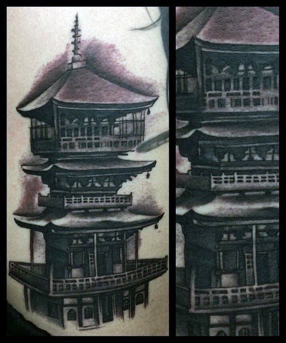 Realistic black and grey tattoo of a multi-level Japanese pagoda with strong shadows and subtle pink-toned cloud accents in the background.