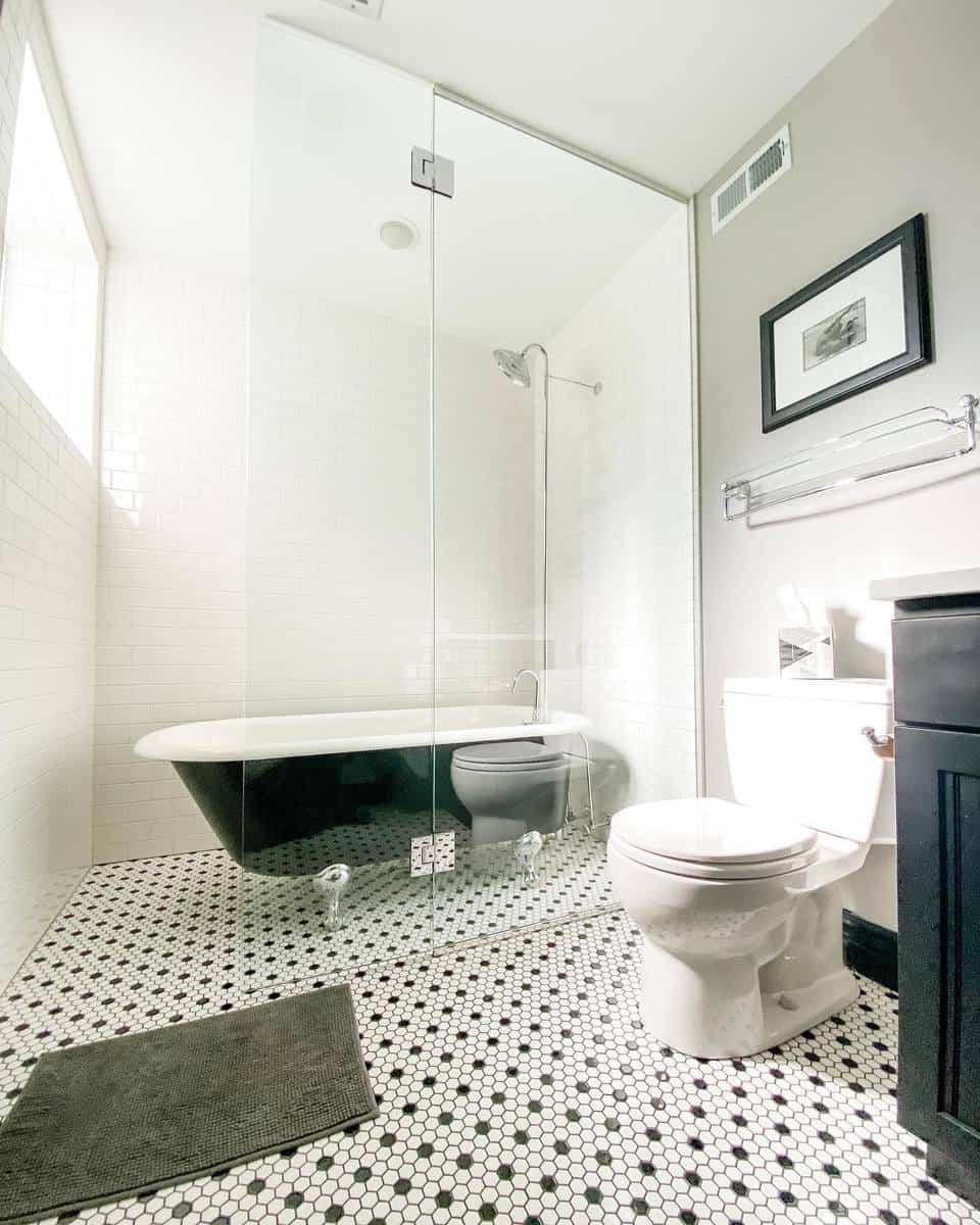 Contemporary bathroom with a black clawfoot tub, glass shower, and hexagonal tile flooring.