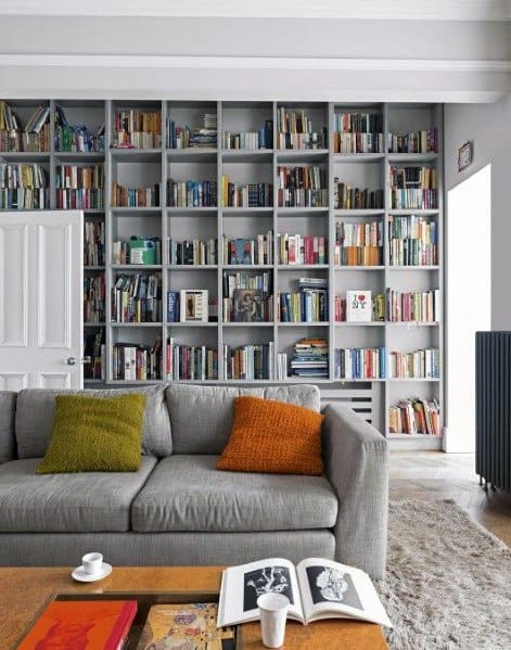 Cozy living room with a sofa, bookshelf, and coffee table adorned with books and cups