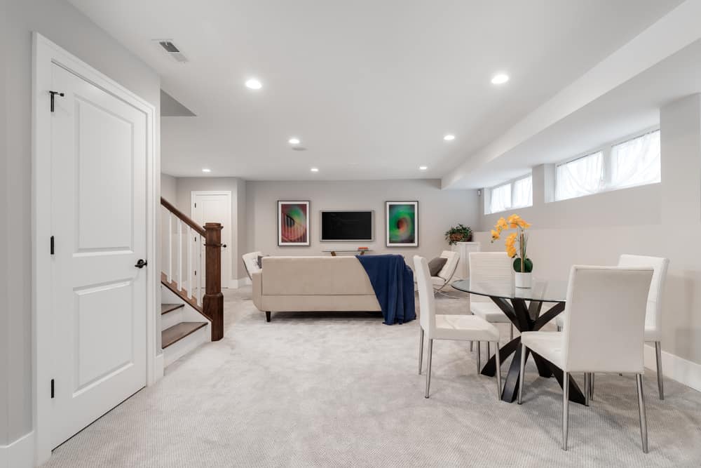 white basement living room with table and chairs