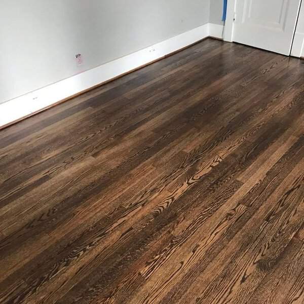 Hardwood floor with a rich walnut stain, showing natural grain and warm brown tones.
