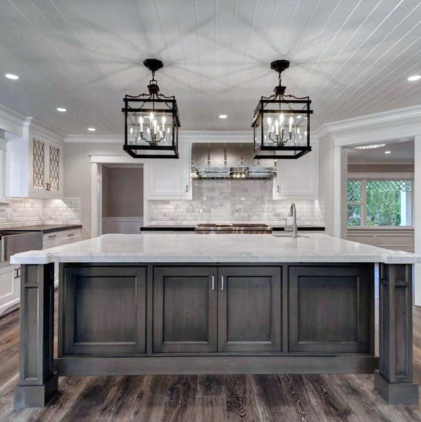 expansive country kitchen with large brown island with marble countertop 