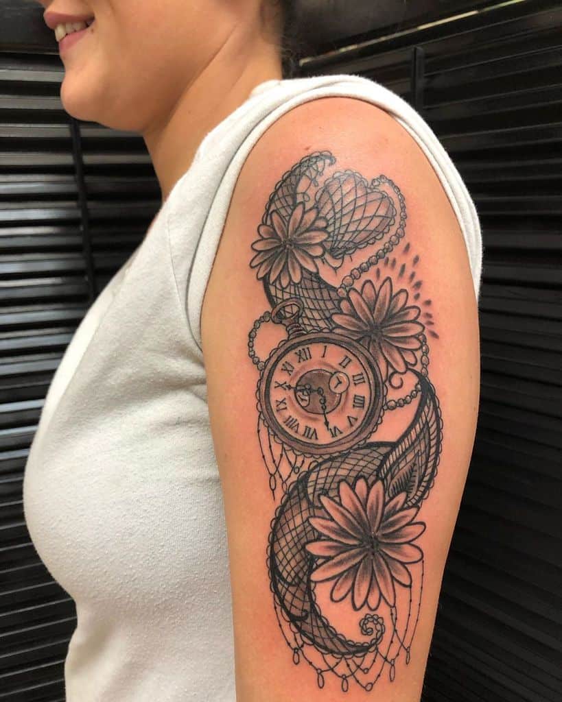 Upper arm tattoo black and grey ornamental paisley pocket watch and daisies