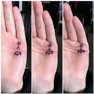 A simple black ink tattoo on the palm featuring a stick figure and a trampoline, designed to create an animated jumping effect when the hand moves.