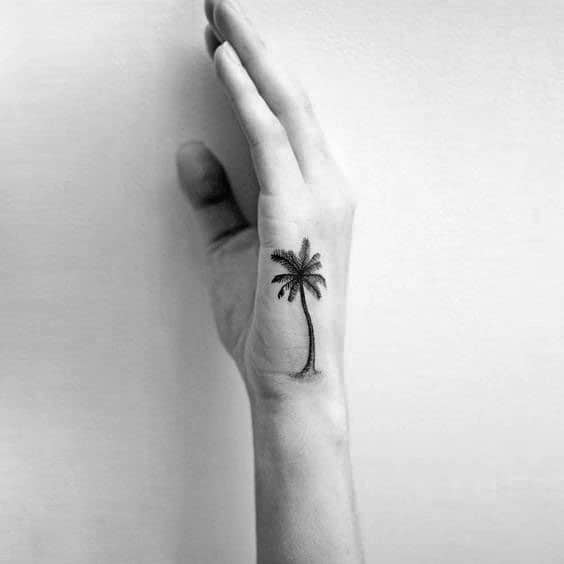 Hand with a small palm tree tattoo on the wrist