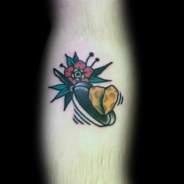 Traditional-style pancake tattoo featuring a pat of butter on a pan with a floral accent, bold outlines, and vibrant colors for a classic look.