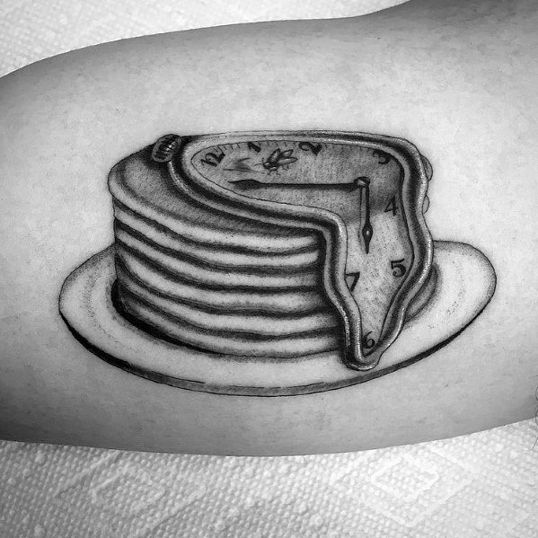 Surreal black and grey pancake tattoo featuring a melting clock draped over a stack, inspired by Salvador Dalí’s iconic artwork.