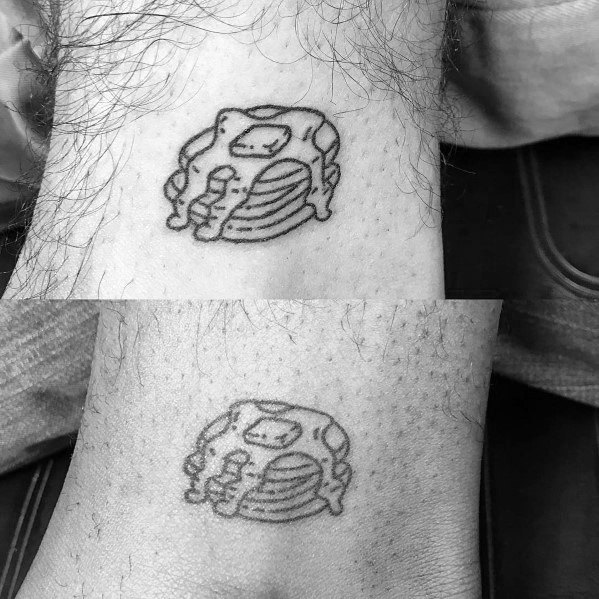 Minimalist pancake tattoo with syrup and butter, done in fine-line black ink on the wrist, featuring a simple and sketch-like design.