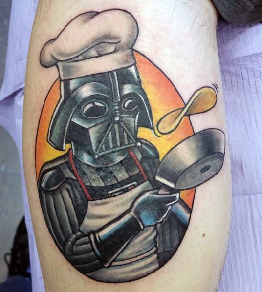 Creative pancake tattoo featuring a Darth Vader-inspired character wearing a chef's hat, flipping a pancake with a spatula, set against a warm background.
