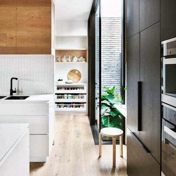 A bright, modern kitchen featuring a minimalist pantry design with natural wood accents and open shelving.
