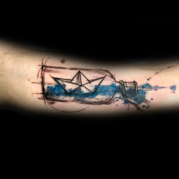Artistic tattoo of a paper boat floating inside a bottle with blue watercolor splashes, symbolizing dreams, adventure, and containment.